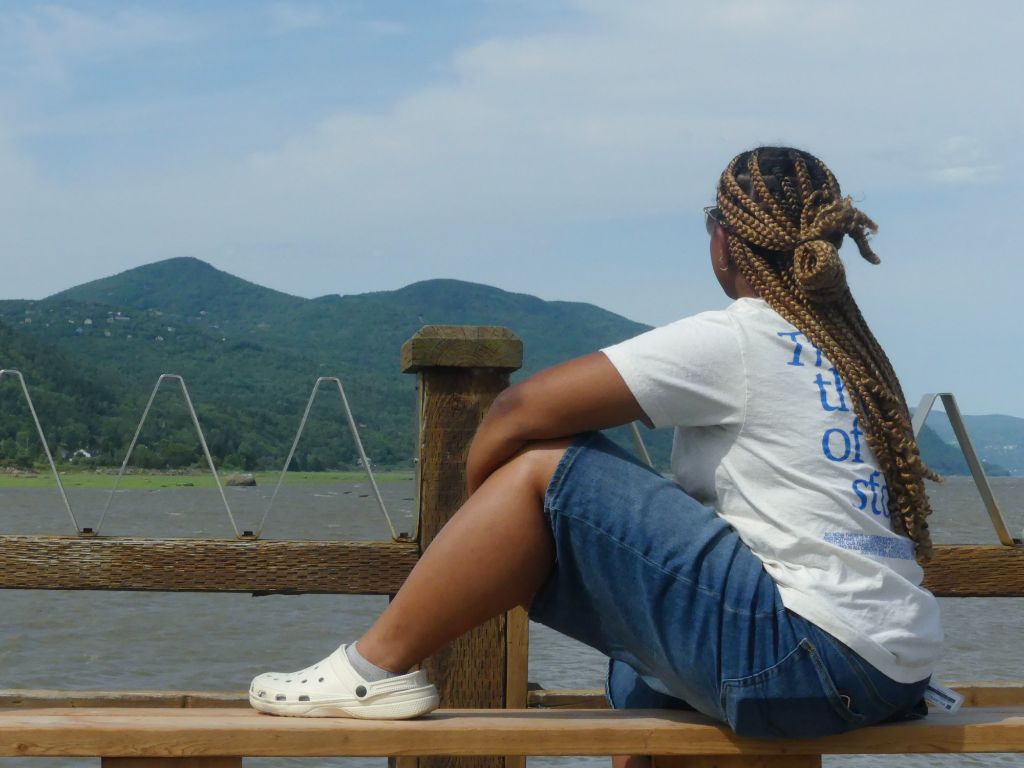 Woman sitting on dock overlooking mountains