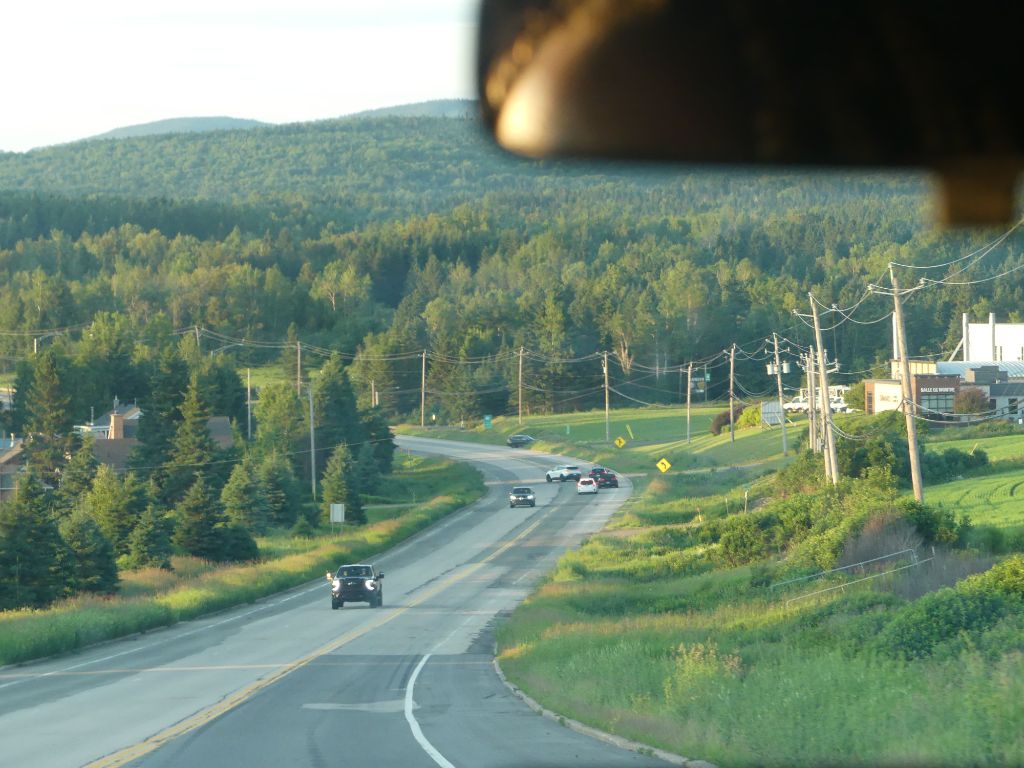 Road winding through forest and mountains at sunset