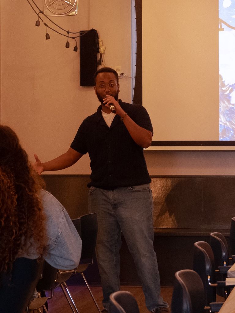 Man speaking at microphone indoors