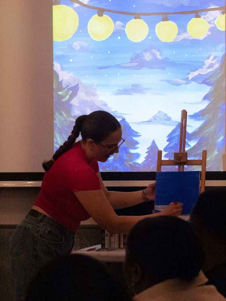 Woman painting on canvas at art event