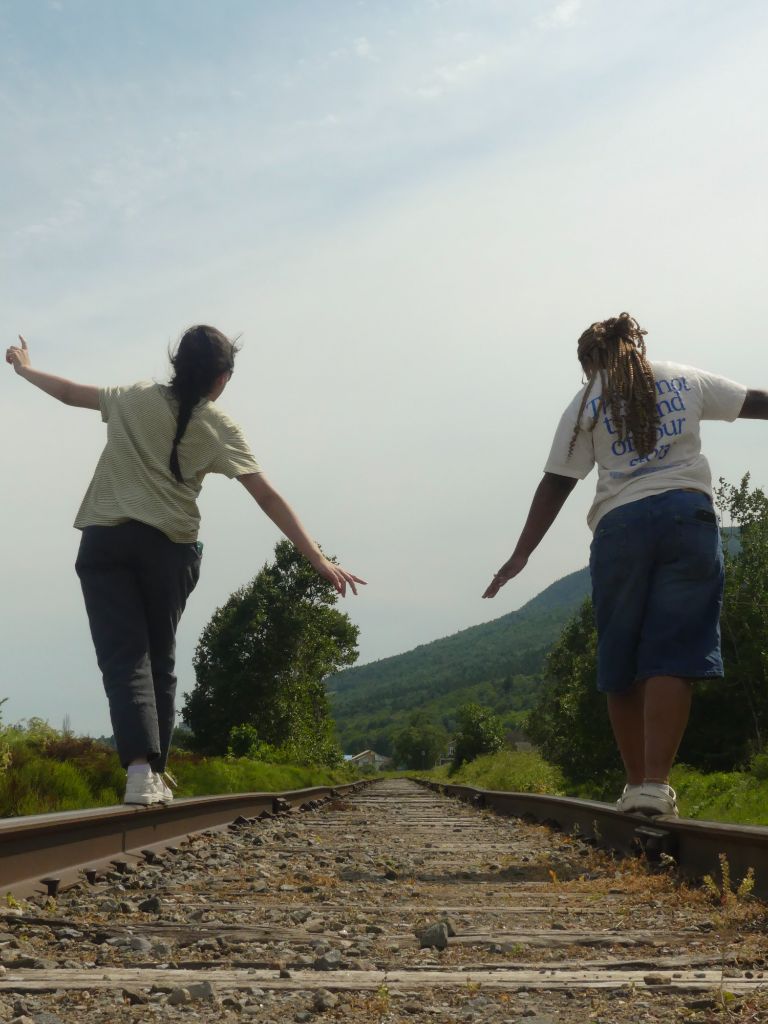 Two people walking on railroad tracks