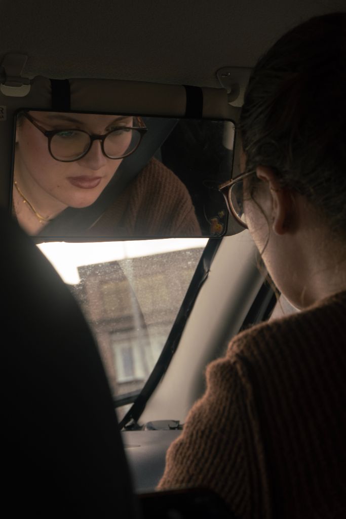 Woman reflected in car mirror