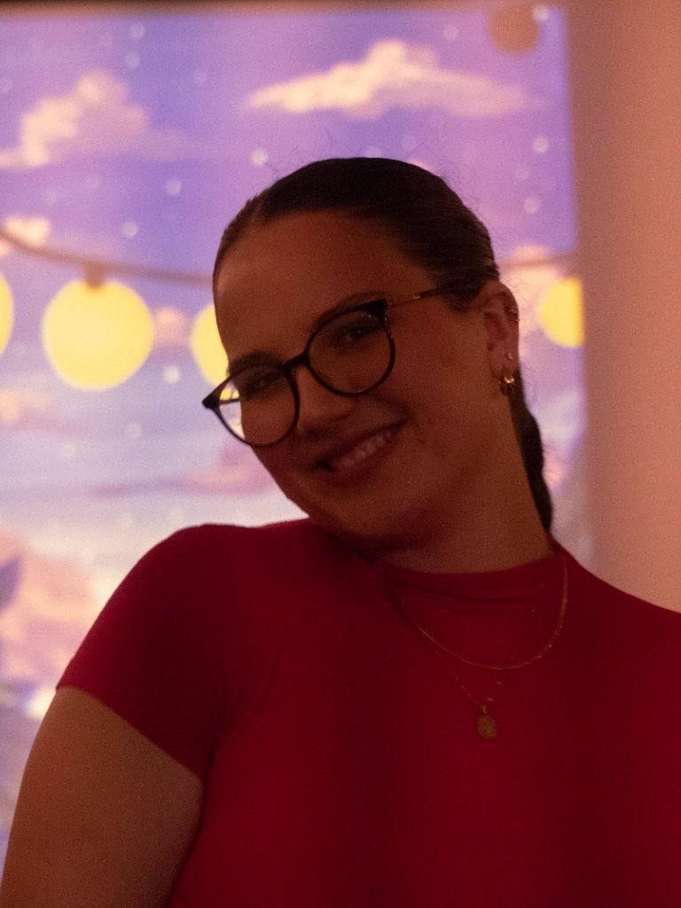 Portrait — Woman with glasses smiling at event