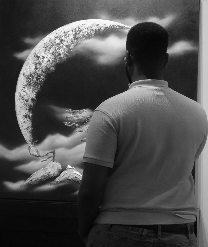 Portrait — Man standing in front of large moon painting